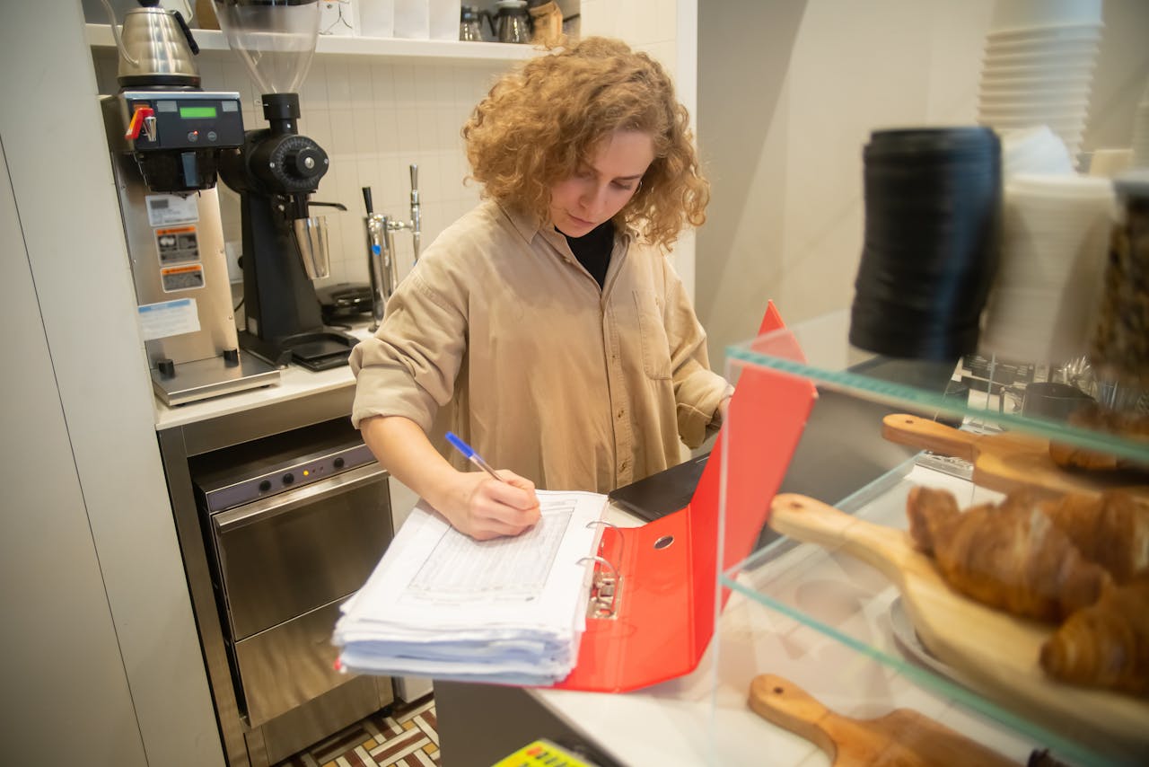 A businesswoman managing inventory in a cozy Portuguese café. Interior setting with baked goods.